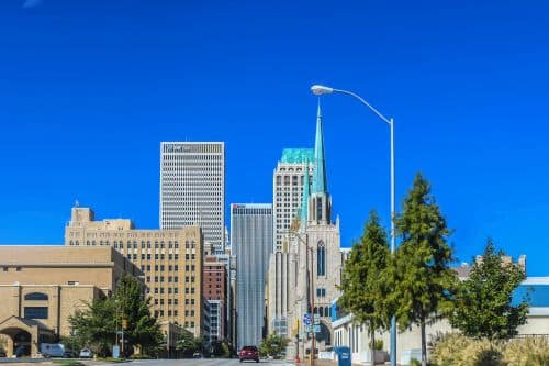 Tulsa USA Art deco and modern skyline of Tulsa Oklahoma with copper spires and roofs viewed from the south with intensely blue sky and car and an ambulance